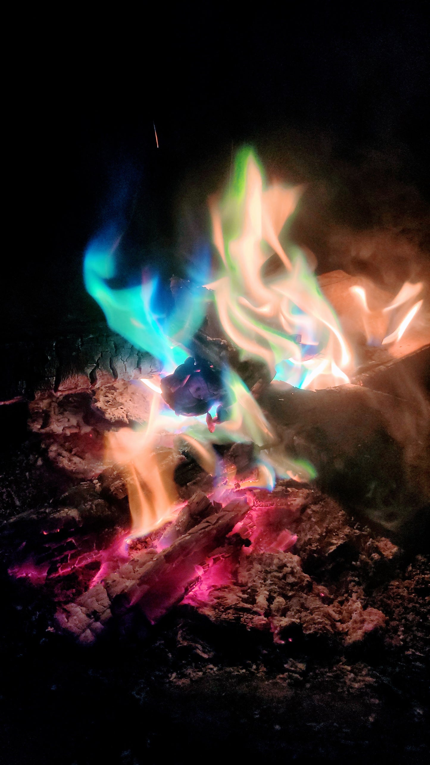 Close-up of Aurora Inferno campfire flames in blue, green, and purple hues